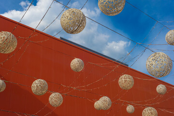 many decorative balls of lamps, against the sky with clouds, a cut of a red building. freedom concept. The bright moment of balloons launching into the sky