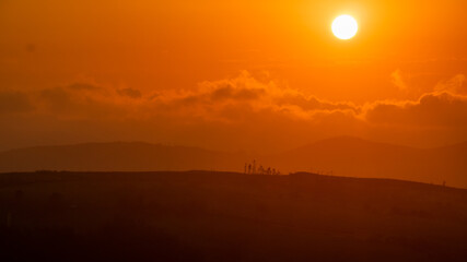 sunset between clouds and mountains in summer