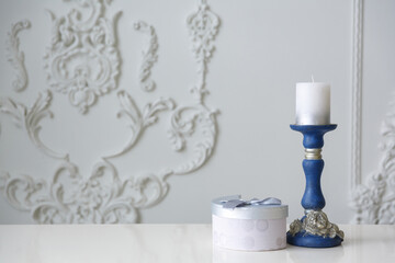 Christmas card. White candle in a blue candlestick on a white background. New year background Space for text and message