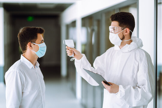 Disease control expert with an Infrared thermometer equipment to check the temperature at office during the coronavirus pandemic. Covid-19. 