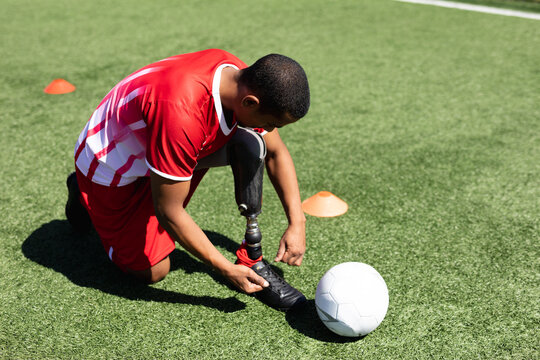 Mixed race male football player with prosthetic leg at a sports field