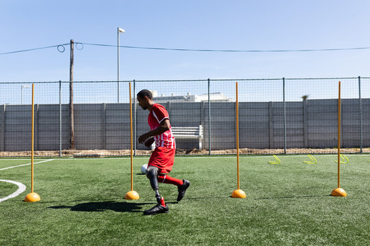 Mixed race male football player with prosthetic leg at a sports field