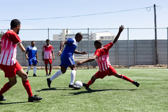 Multi ethnic team of male football players training at a sports field 