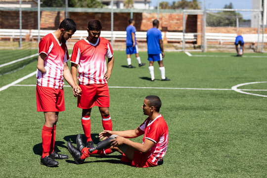 Multi ethnic team of male football players training at a sports field - Powered by Adobe