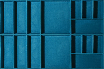 A box with partitions for storing small items, common in blue baize, as a background or a template for your creativity.