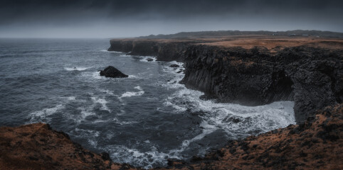 Western Iceland nature landscape, panorama view. Basalt rock cliff in Snaefellsnes (Snæfellsnes) peninsula near Arnarstapi village. Stormy waves at rainy weather