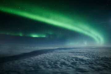 Northern lights or Aurora Borealis above the clouds, view from plane. Night sky landscape