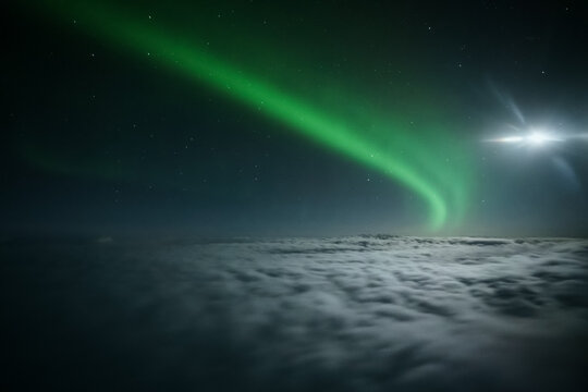 Northern lights or Aurora Borealis above the clouds, view from plane. Night sky landscape