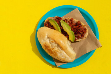 Mexican chorizo sandwich also called torta on yellow background