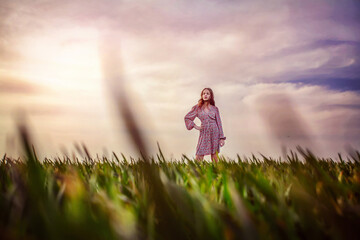 Girl stands on a green field in spring