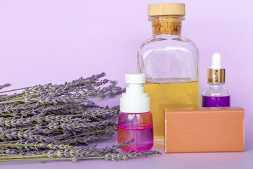 Obraz na płótnie Canvas Lavender Soap, Lavande oil, lavander hydrolyte and bouquet on violet background, Homemade cosmetics, Beauty Concept