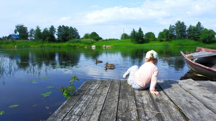 Summer river girl and ducks