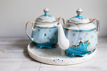 A blue porcelain tea set on the table. Teapot and cups of tea.