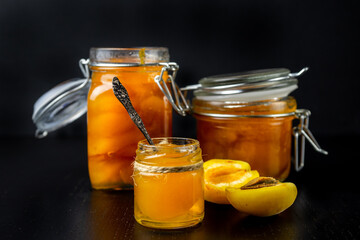 Apricot jam in glass jars on a black background. Organic sweets