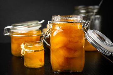 homemade organic apricot jam  and ripe apricots on black background