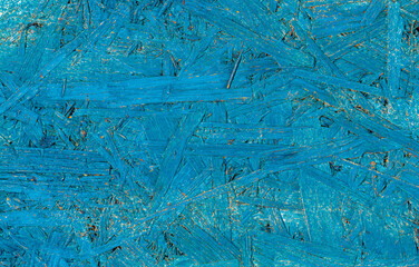 Blue painted pressed wooden textured bakground, waferboard close-up.