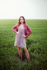 Girl stands on a green field in spring