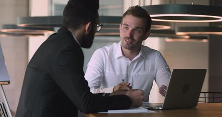 Confident male caucasian financial consultant adviser expert talking to arab client customer explain commercial investment deal benefit show computer presentation at bank loan negotiation meeting - Powered by Adobe