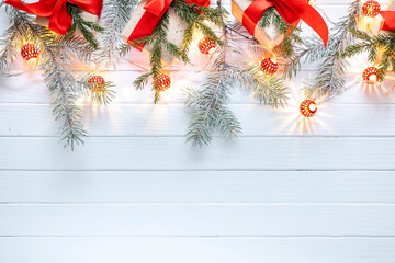 Christmas decoration of fir branches, New Year's lanterns and gifts on a white wooden background. Top view. Flat lay.