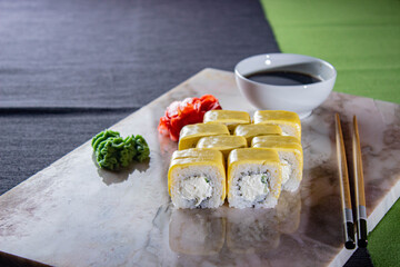 Sushi. A serving of fresh Japanese rolls on a marble board with soy sauce, wasabi and pickled ginger.