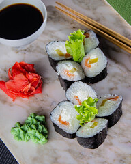 Sushi. A serving of fresh Japanese rolls on a marble board with soy sauce, wasabi and pickled ginger.