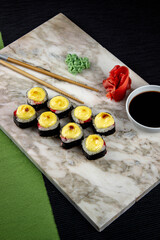 Sushi. A serving of fresh Japanese rolls on a marble board with soy sauce, wasabi and pickled ginger.