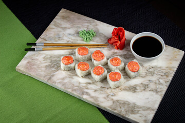 Sushi. A serving of fresh Japanese rolls on a marble board with soy sauce, wasabi and pickled ginger.