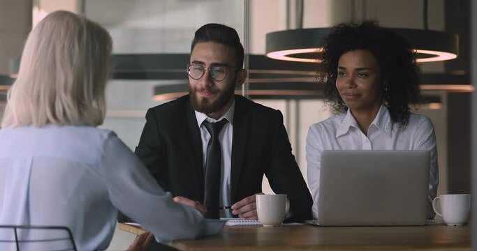 Happy young african and arab hr managers recruiters employers handshake caucasian old middle aged female applicant get hired employed at job interview meeting, human resource, recruit concept