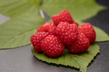 Close up of raspberries on a leaf.