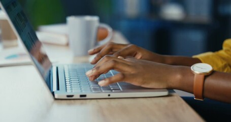 Close up shot of African American female hands typing on laptop while sitting at office desk indoors. Woman fingers tapping and texting on computer keyboard while working in cabinet. Work concept - Powered by Adobe
