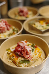 Preparing a ham salad with rice to take away. The containers used are compostable.
