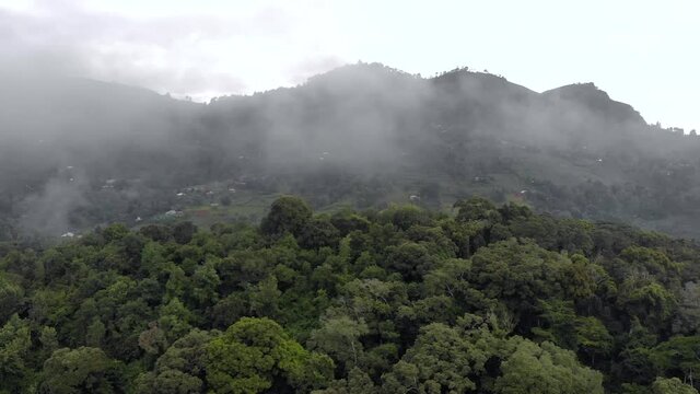 Aerial Drone Shot Flying by Cloudy Misty Foggy Lushoto village in Usambara Mountains. Remote Place in Tanga Province, Tanzania, Africa