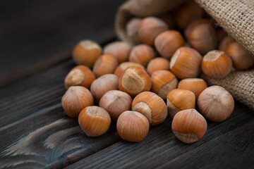 Hazelnuts on a wooden dark background close-up.