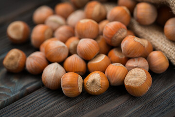 Hazelnuts on a wooden dark background close-up.