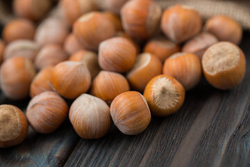 Hazelnuts on a wooden dark background close-up.
