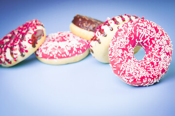 Multicolored sweet donuts on violet background.