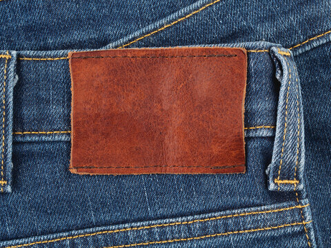 Blank leather label on a blue denim jeans, fabric background with copy space