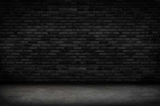 Empty black brick wall and concrete floor for background. Dark room interior with black brick wall blank cement floor for backdrop.