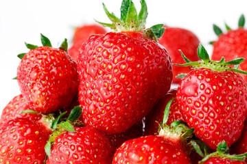 large pile of strawberries on white isolated background, fine small water drops on several berries for fresh tasty cool look