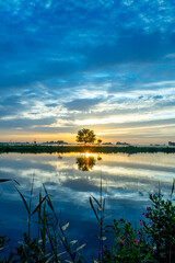 Sunrise over the meadows of the Zwanburgerpolder at the Kagerplassen in the South-Holland village of Warmond in the Netherlands.