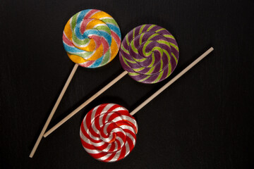 Fruit colored round lollipops on a black background
