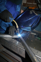 Electric arc welding. The worker welding two iron corners.