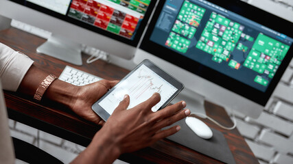 More than just money. Close up shot of hands holding tablet pc. Trader is using touch screen tablet...