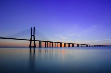 Beautiful sunrise at Vasco da Gama Bridge, the longest bridge in Europe, who spans the Tagus River in Lisbon, Portugal.