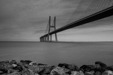 Vasco da Gama Bridge, the longest bridge in Europe, spans the Tagus River, in Lisbon, Portugal. Long exposure, black and white