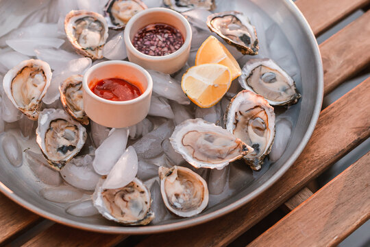 Oyster Platter With Minced Shallot In Red Vinegar And Horseradish Tomato Sauce. Seafood Plate. Ocean Meal. Raw Seafood. Lemon Slices. Fresh And Nutritional Dinner. Luxury Meal. Fancy Dinner.