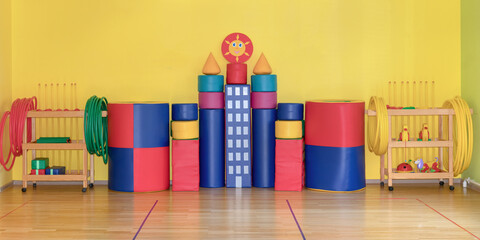 empty gym with children playground and kid equipment yellow wall background