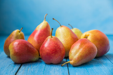 Ripe pears on a blue wooden background. Beautiful photo of fruits