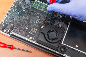 Service engineer fixing laptop fun. Repairing laptop concept. Close up view.