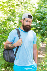 Naklejka na ściany i meble Relaxing hiking Experience. Bearded man carry backpack. ready for camping. male tourist wear cap. sport and fitness clothes. Confident and handsome brutal man. brutal caucasian hipster with moustache